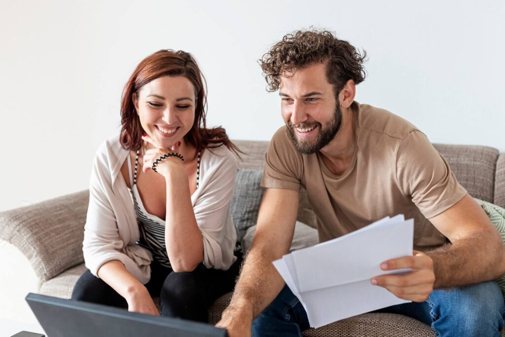 Casal feliz a analisar propostas de crédito negociadas pelo Crédito Poupança